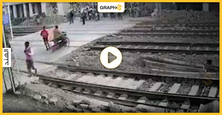 بالفيديو|| مشهد مثير.. لحظات فصلت الموت عن قائد دراجة نارية أمام قطار سريع بالهند